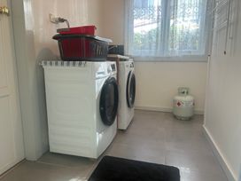 A laundry room with washing machine and dryer at The Beach House - Paihia