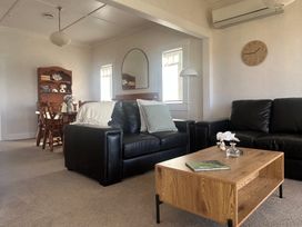 A living room with a sofa and coffee table at The Beach House - Paihia Holiday Home