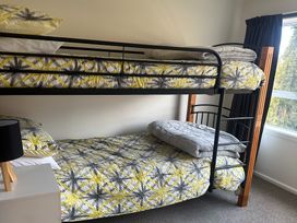 A bunk bed with pillows and linens in a bedroom at Pops Place - Omarama Holiday Home