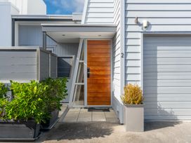 An entryway with a wooden door beside a garage at Fresh on Fletcher - Lake Taupo