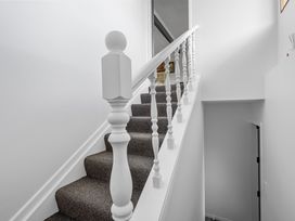 A staircase with a white handrail and carpet at Coastal Charm - Picton Holiday Home in Picton