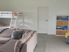 A living room with a bunk bed and a couch at Mangawhai Magic - Mangawhai Heads
