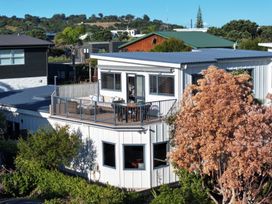 An outdoor balcony with a table and chairs at Omaha Beach House - Omaha Holiday Home