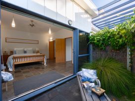 A bedroom with a bed and bedside tables at Omaha Beach House - Omaha Holiday Home
