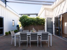 An outdoor patio with a table and chairs at Omaha Beach House - Omaha