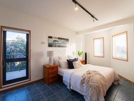 A bedroom with a bed and a side table at Omaha Beach House - Omaha Holiday Home