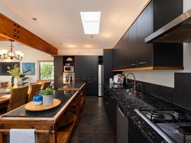 A kitchen with a refrigerator and sink at Omaha Beach House - Omaha Holiday Home