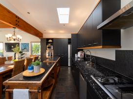 A kitchen with cabinets, sink, stove, and dining area at Omaha Beach House - Omaha