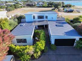 An outdoor view of a house with a garden and driveway at Omaha Beach House - Omaha