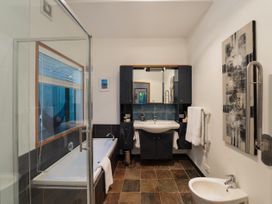 A bathroom with a shower and bathtub at Omaha Beach House - Omaha Holiday Home