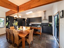 A kitchen with a dining area and kitchen appliances at Omaha Beach House - Omaha Holiday Home