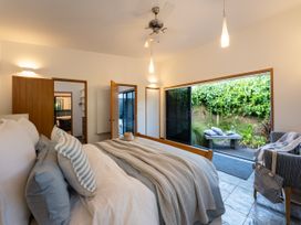 A bedroom with a bed and access to an outdoor area at Omaha Beach House - Omaha Holiday Home
