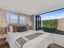 A bedroom with a bed and window at Sun Kissed Pool Villa - Mangawhai Holiday Home Mangawhai Heads