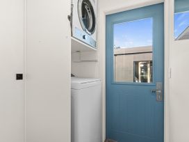 A laundry room with washing machine and dryer at Sun Kissed Pool Villa - Mangawhai Heads