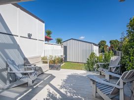 An outdoor area with chairs and a shed at Sun Kissed Pool Villa - Mangawhai Heads