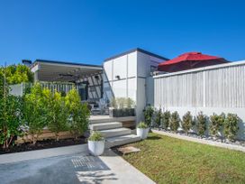 An outdoor area with a deck and plants at Sun Kissed Pool Villa - Mangawhai Heads