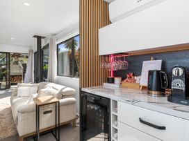A living room with a sofa and coffee station at Sun Kissed Pool Villa - Mangawhai Heads