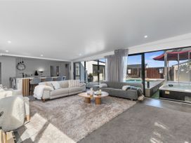 A living room with sofas and a coffee table at Sun Kissed Pool Villa - Mangawhai Heads