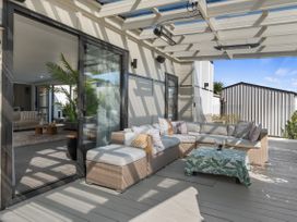 An outdoor living area with a sofa and coffee table at Sun Kissed Pool Villa - Mangawhai Heads