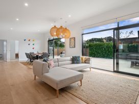 A living room with a sofa and dining area at House Naomi - Martinborough Holiday Home Martinborough