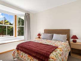 A bedroom with a bed and window at Kauri Cottage at Marble Hills - Marahau