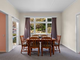 A dining room with a table and chairs at Kauri Cottage at Marble Hills - Marahau