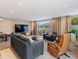 A living room with a television and sofa at Waimahana 5 - Taupo Holiday Apartment in Waipahihi