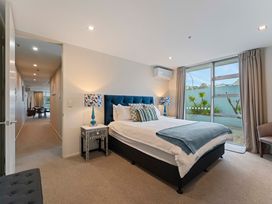 A bedroom with a bed and bedside table at Waimahana 5 - Taupo Holiday Apartment in Waipahihi