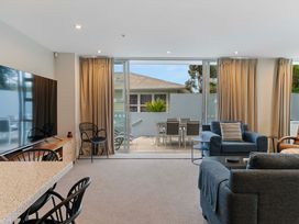 A living room with a television and a sofa at Waimahana 5 - Taupo Holiday Apartment in Waipahihi