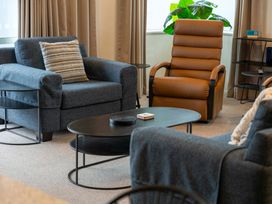 A seating area with a couch and armchair at Waimahana 5 - Taupo Holiday Apartment, Waipahihi