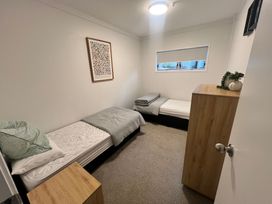 A bedroom with two beds and a chest of drawers at Sol Vista Paku - Pauanui Holiday Home Pauanui