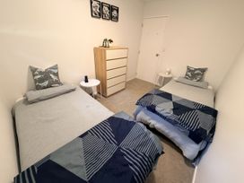 A bedroom with two single beds and a drawer unit at Sol Vista Paku - Pauanui Holiday Home in Pauanui