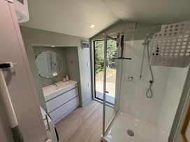 A bathroom with a shower and wash basin at Sol Vista Paku - Pauanui