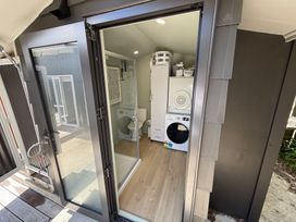 A laundry room with toilet and appliances at Sol Vista Paku - Pauanui