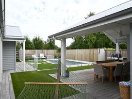 An outdoor area with a swimming pool, hammock, and dining set at Modern Deluxe - Havelock North Holiday Home, Havelock North