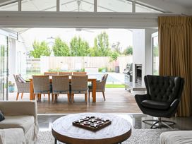 A living room with an outdoor dining area and pool at Modern Deluxe - Havelock North Holiday Home, Havelock North