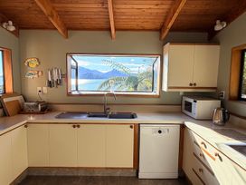 A kitchen with a sink, cabinets, and appliances at Moetapu Bay Bliss - Marlborough Sounds Retreat, Moetapu Bay