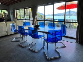 A dining room with a table and blue chairs at Moetapu Bay Bliss - Marlborough Sounds Retreat, Moetapu Bay