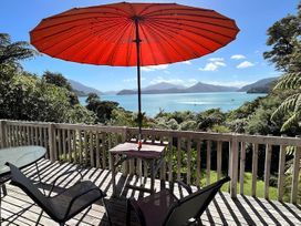 An outdoor seating area with a table and chairs at Moetapu Bay Bliss - Marlborough Sounds Retreat in Moetapu Bay