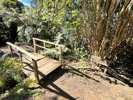 A wooden bridge leading to a beach in a forested area at Moetapu Bay Bliss - Marlborough Sounds Retreat, Moetapu Bay