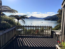 A deck with a table overlooking the water at Moetapu Bay Bliss - Marlborough Sounds Retreat, Moetapu Bay