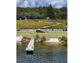An outdoor area with a dock, water, and houses at Lakefront Luxury - Lake Rotoiti Holiday Home, Lake Rotoiti