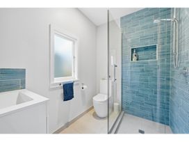 A bathroom with a shower and bathtub at Bayview Beauty - Charteris Bay