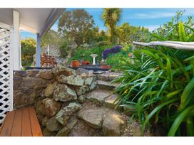 A garden with stone steps and flower pots at Bayview Beauty - Charteris Bay