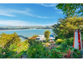 A view of a garden and water at Bayview Beauty - Charteris Bay Holiday Home Charteris Bay