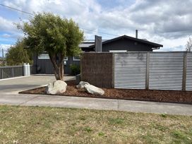 An outdoor photo of a house with a tree and rocks at Willow Lake House - Lake Taupo Holiday Home, Rainbow Point