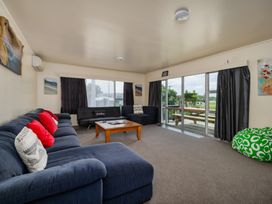A living room with a sofa and coffee table at Te Tiriti Beach House - Paihia
