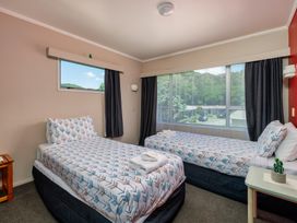 A bedroom with two beds and a window at Te Tiriti Beach House - Paihia