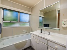 A bathroom with a sink and bath tub at Te Tiriti Beach House - Paihia