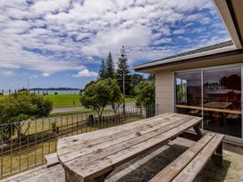 An outdoor seating area with a wooden table and benches at Te Tiriti Beach House - Paihia